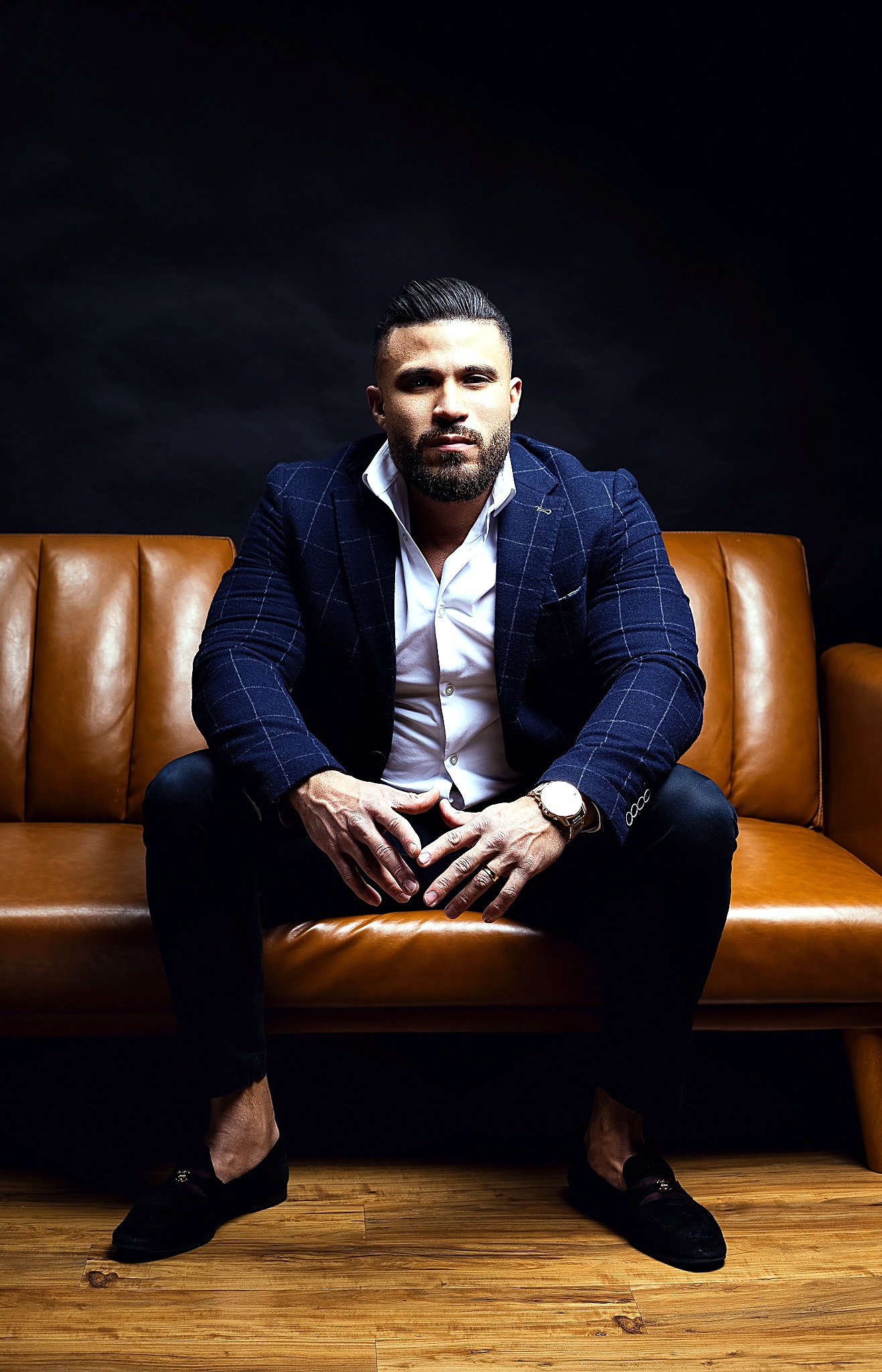 Lucas Lima seated on a brown leather couch