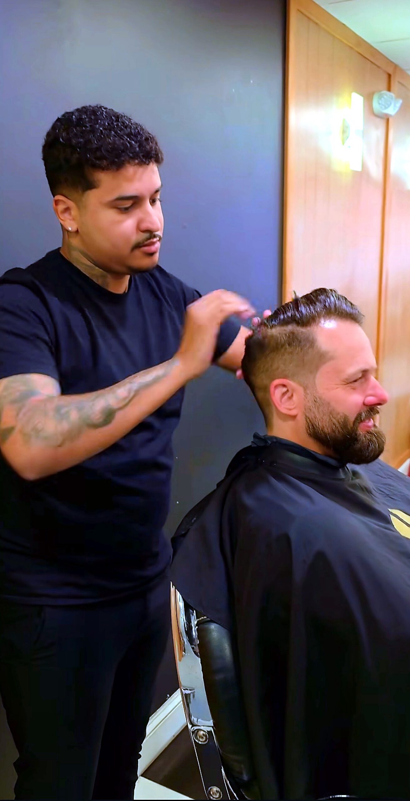 Barber styling a bearded client's hair