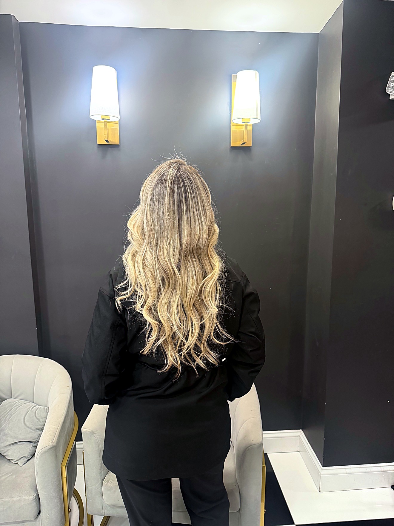 Blonde long wavy hair, back view, in the salon