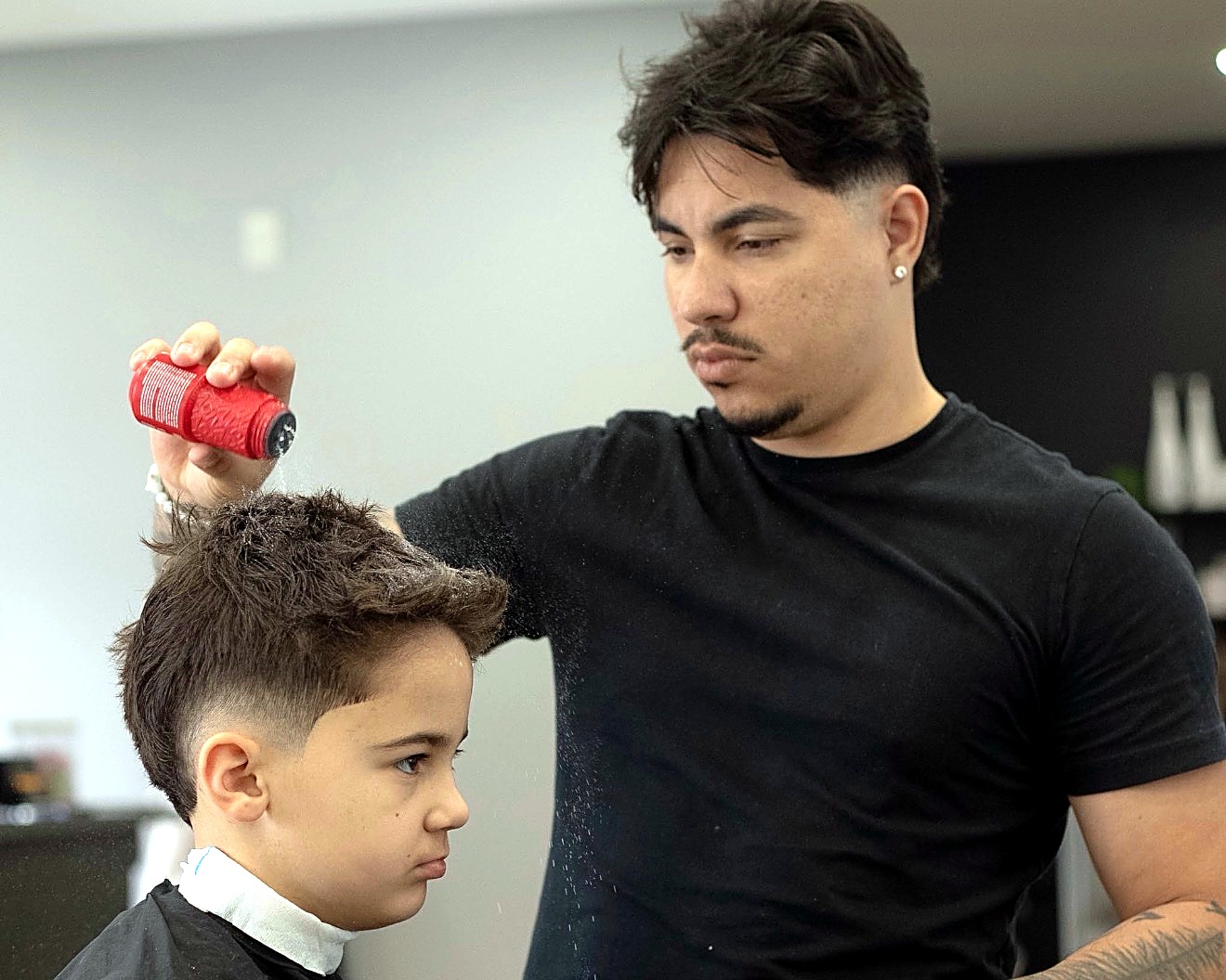 Barber applying product to a kid's hair
