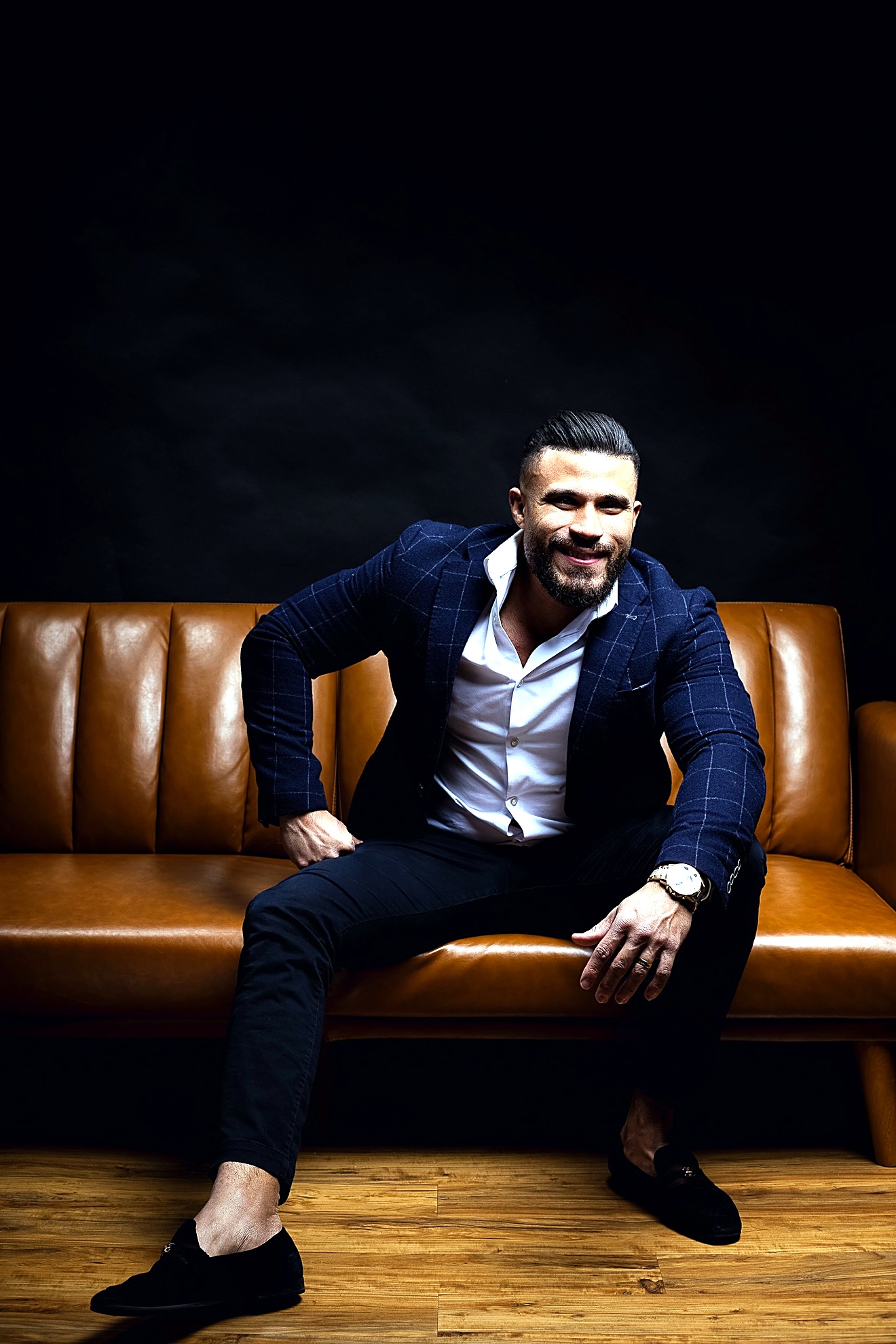Lucas Lima smiling on a brown leather couch