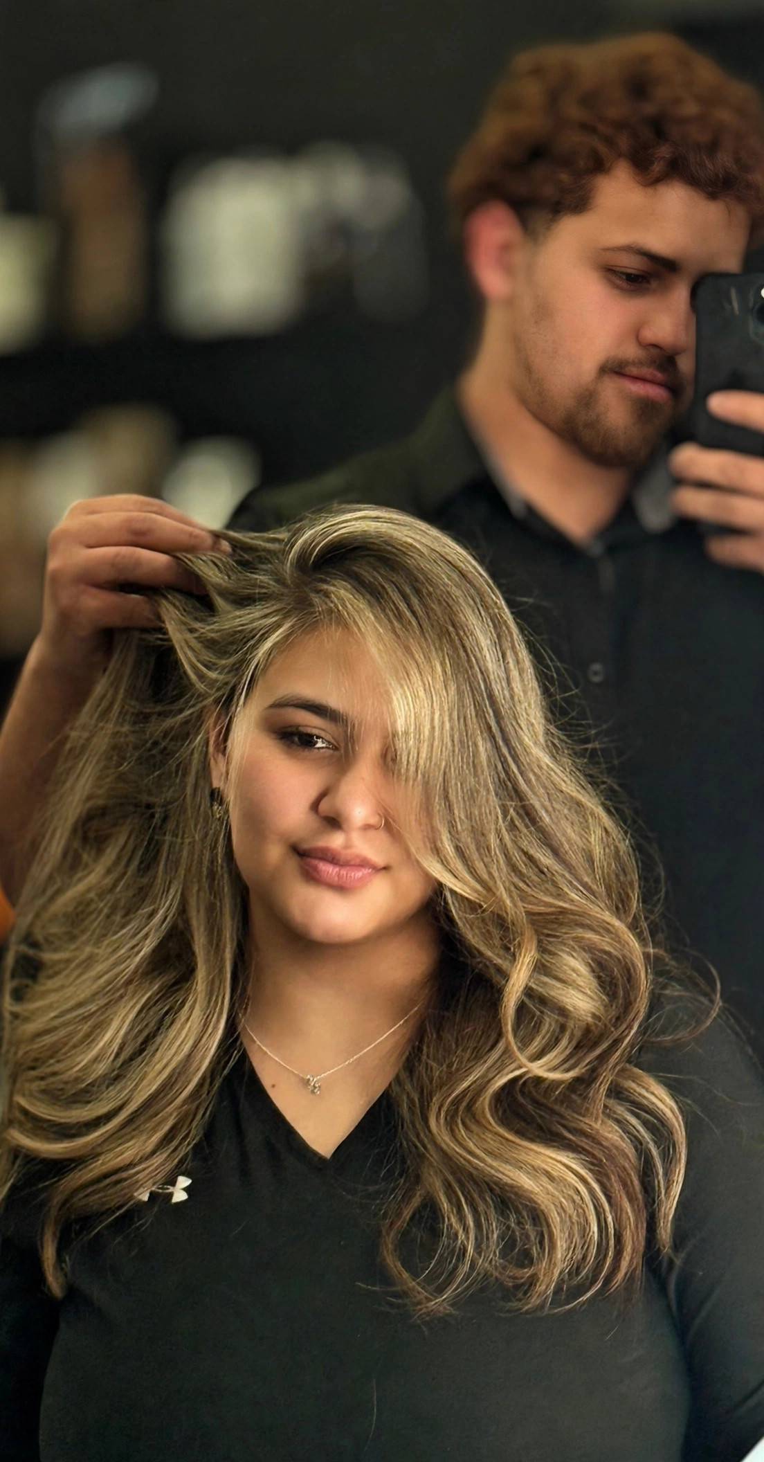 Hairdresser working on a blonde client's hair